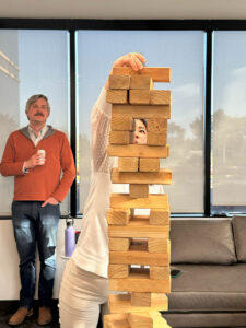 Woman stacks another block on the Jenga tower