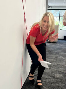 Team member laughing while grabbing a clue from an accent wall