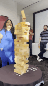 A woman in blue dances with Jenga blocks