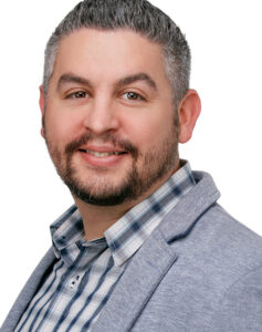 Nic Goddard, Designer III, smiling in a professional headshot