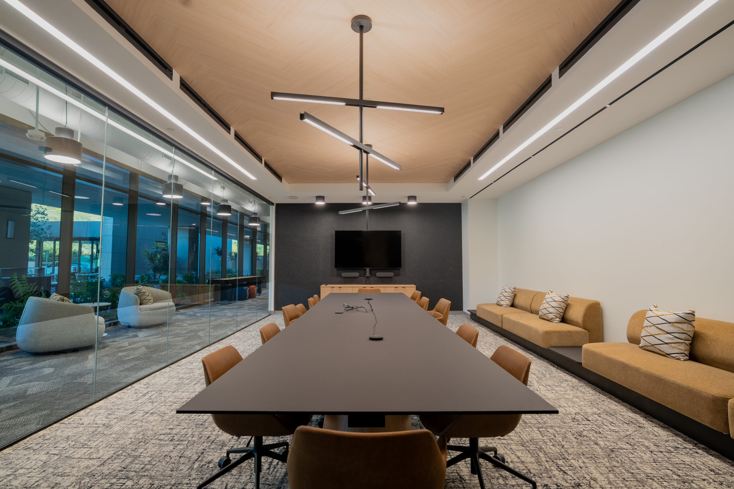 Modern conference room featuring a long, dark wood table surrounded by swivel chairs at Healthpeak Properties, 4930 Directors Place in San Diego, CA.