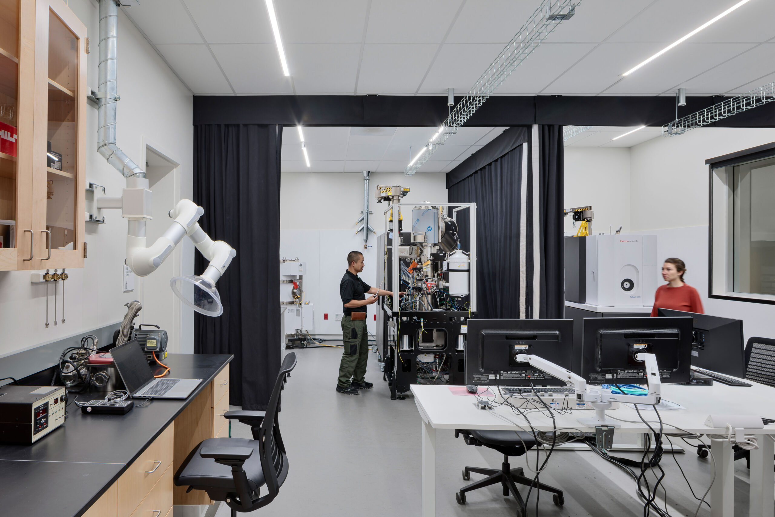 A researcher calibrates sensitive lab equipment in the DEEP Lab, built to support advanced research training. A CAS Architects, an FPBA Co. and Jensen Architects education project.