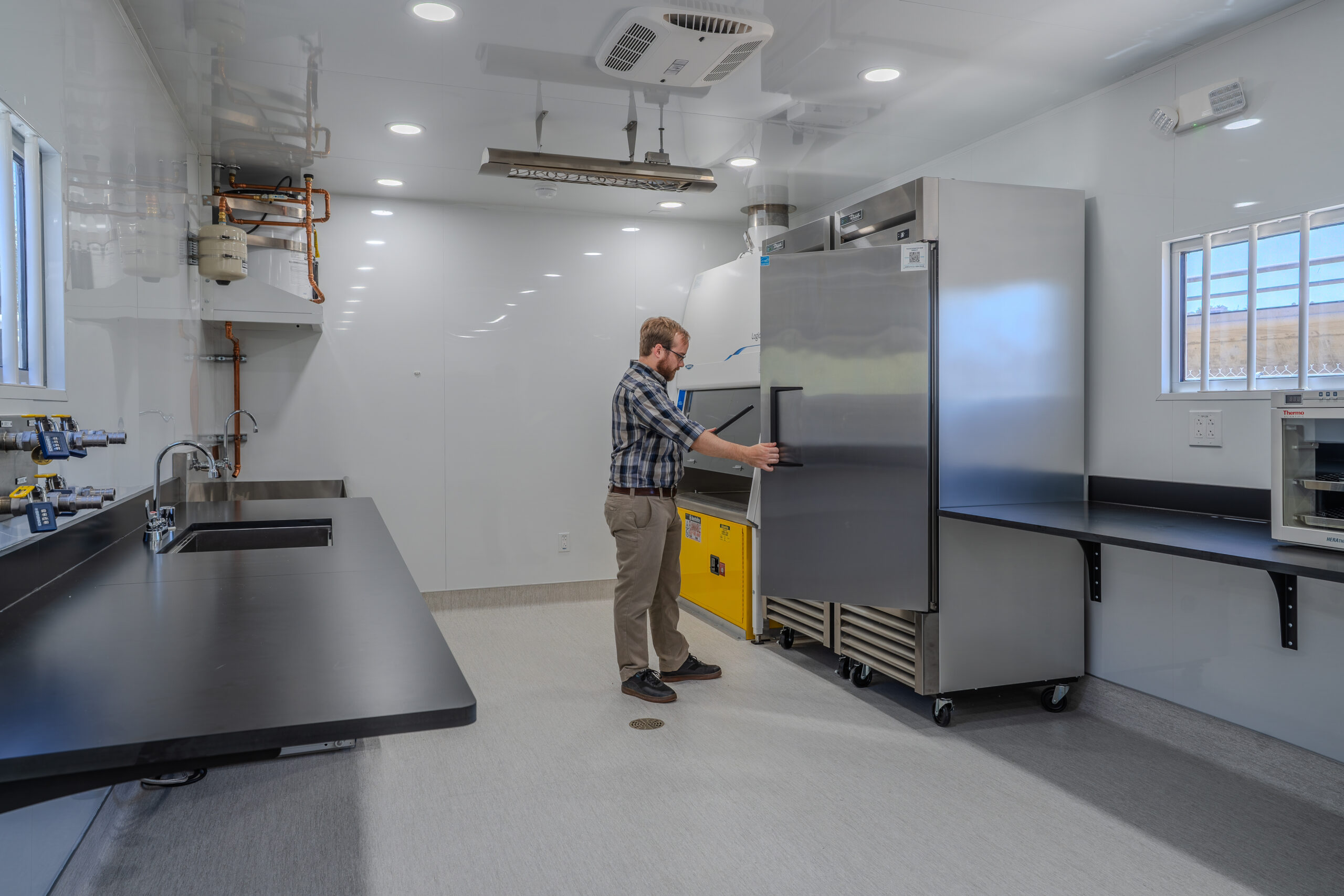An individual opens a lab refrigerator inside SDSU's One Water Laboratory, an FPBA higher education project for San Diego State University in Mission Valley.